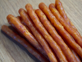 Traditional Polish sausages Kabanos on a wooden surface, macro photo. Kabanos, also known as cabanossi or kabana, is a long, thin, dry sausage usually made of pork which originated in Poland.