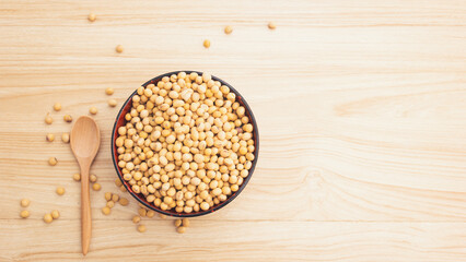 soybean in a bowl with wooden spoon on wooden background, top view, flat lay, top-down, selective focus.copy space.