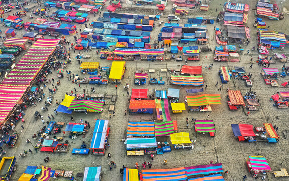 Aerial view of traditional village fair in Bangladesh. Colorful tents of temporary shops make it look like blocks of tetris game.  Portable ferris wheel