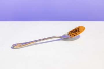 cinnamon spoon on white and blue background