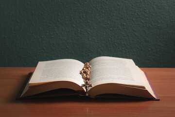 Cross on the holy bible on a wooden table