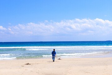 南伊豆の美しい吉佐美大浜の砂浜を歩く女性
