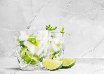 Two glasses of mojito and bar accessories. Mojito cocktail on a desk. Cocktail with lime and mint