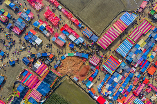 Aerial view of traditional village fair in Bangladesh. Colorful tents of temporary shops make it look like blocks of tetris game.  Portable ferris wheel