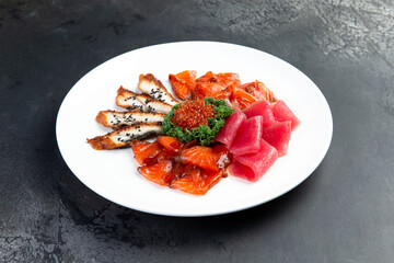 Assorted fish cut into slices. Salmon, eel, tuna, trout. Decorated with red caviar.