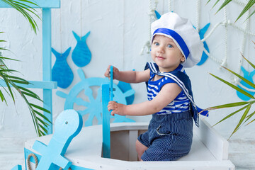 baby in the sea zone with a ship in a sailor's vest, the concept of summer and travel