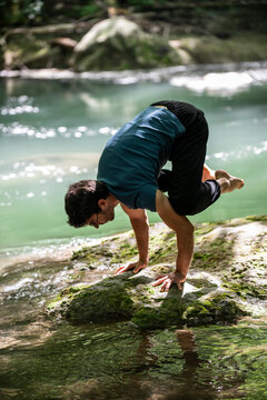 boy doing yoga by the river