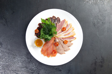 Meat delicacies on plate. On a gray background.