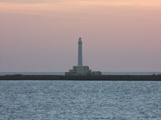 Lighthouse with purple and orange sky. Sunset in Gallipoli, Italy. 