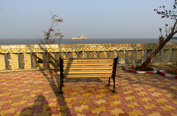 Fototapeta na wymiar A wooden bench at a viewpoint to Panikota Fort in the town of Diu, India