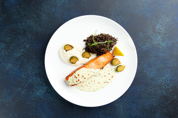 Salmon steak and black rice in a bowl.