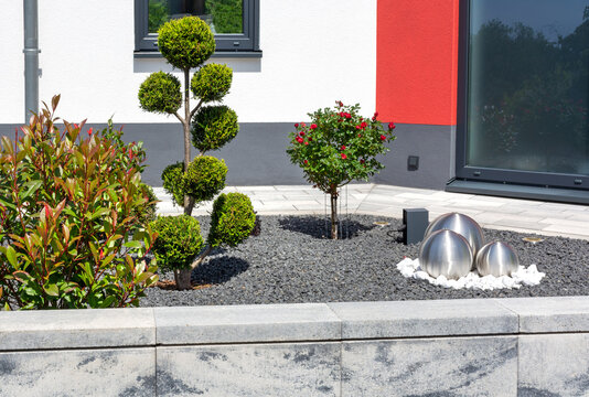 Moderner Vorgarten Gestaltung Schottergarten Steingarten mit Pflanzen in Formschnitt, Außensteckdose, Beleuchtung und Kugelspringbrunnen
