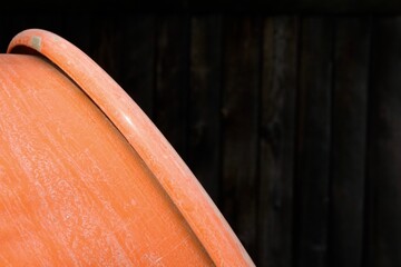 Cement mixer background showing orange drum against wooden fence