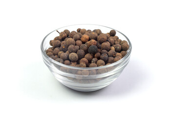allspice (pimento) in a glass bowl isolated on white background