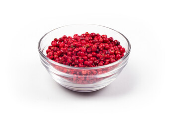 pink peppercorns in a glass bowl isolated on white background