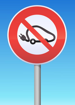Prohibition road sign with the symbol of the electric car on a pole with a blue sky in the background