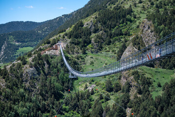 People walking on the longest Tibetan bridge in Europe, 600 meters long and 200 meters high in the Parish of Canillo in Andorra.