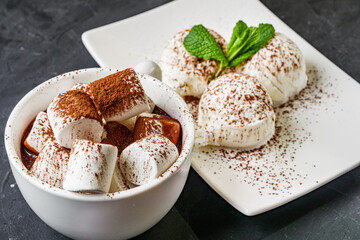 hot chocolate with marshmallows and ice cream balls on a black background