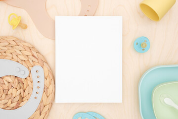 Baby accessories and tableware for food on wooden background. Blank greeting card, invitation...