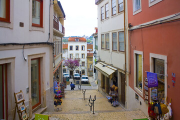 Fototapeta na wymiar Picturesque street with ancient houses in Old Upper Town of Coimbra, Portugal 