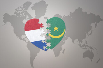 puzzle heart with the national flag of mauritania and netherlands on a world map background.Concept.