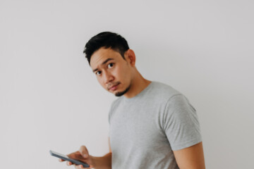 Worry face of asian man using mobile application on white background.