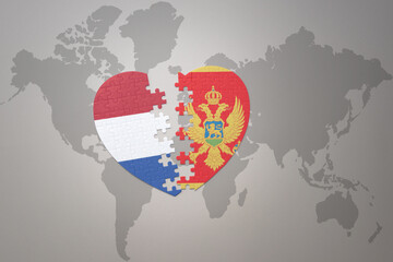 puzzle heart with the national flag of montenegro and netherlands on a world map background.Concept.