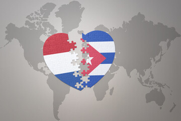 puzzle heart with the national flag of cuba and netherlands on a world map background.Concept.