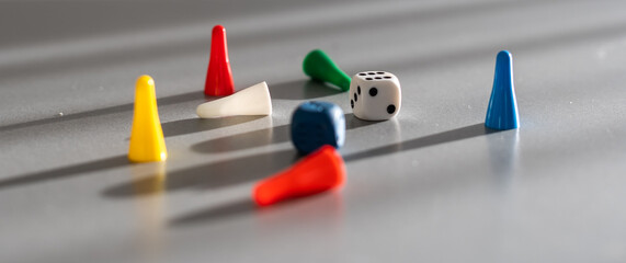 Colorful game chips and two dice are laid out on a gray background: entertainment, games at home...