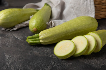 Slices of squash vegetable marrow zucchini on black texture background.Vegetarian organic vegetables.Healthy food.Copy space.Place for text
