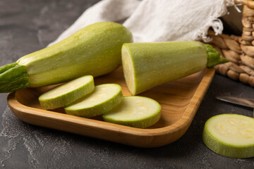Slices of squash vegetable marrow zucchini on black texture background.Vegetarian organic vegetables.Healthy food.Copy space.Place for text