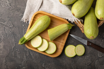 Slices of squash vegetable marrow zucchini on black texture background.Vegetarian organic vegetables.Healthy food.Copy space.Place for text