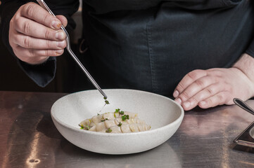 chef decorates food with microgreens