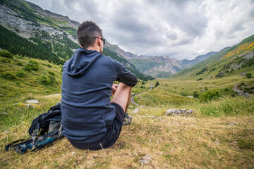 Naklejka na ściany i meble Men hiker resting in front of the Otal valley, Ordesa y Monte Perdido national park.