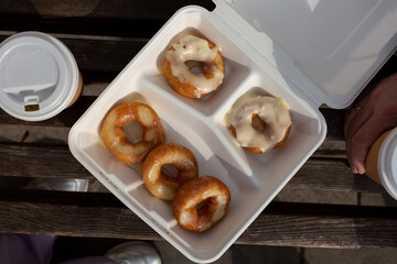 On a bench in the park, a sweet snack with donuts and takeaway coffee, food delivery, outdoor cafe, a break with a colleague, with a friend, a date in the middle of the working day, flat lay