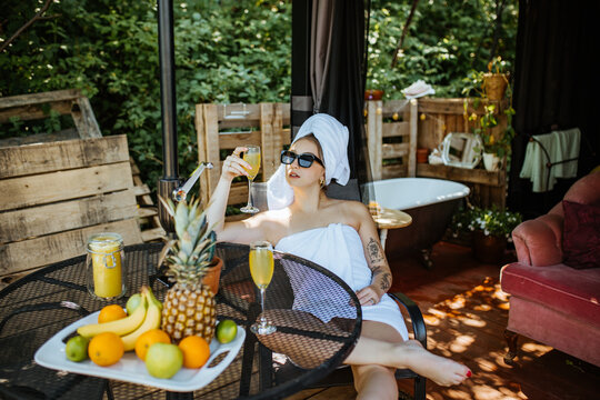 Woman in towels drinking cocktail on terrace