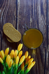 Fototapeta na wymiar Turmeric infusion on a rustic table, decorated with a bouquet of yellow flowers. Zenith view and copy space. 