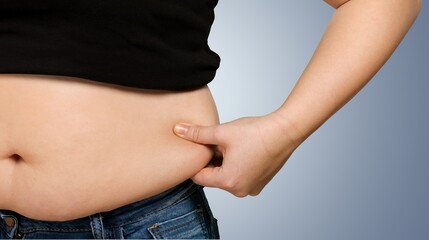 The girl stomach, showing fat deposits. Subcutaneous fat concept.