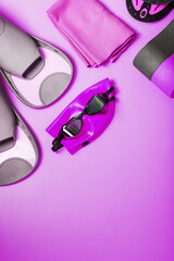 Equipment for swimming in the pool and in the sea on a pink background