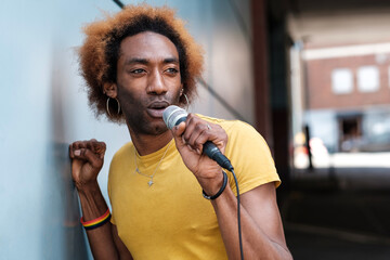 A young non-binary singer is performing in a street of London.