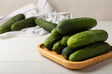 Fresh cucumbers on white texture wood. Vegetarian organic vegetables.Ingredient for salad. Healthy food.Copy space.Place for text