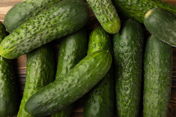 Fresh cucumbers on brown texture wood. Vegetarian organic vegetables.Ingredient for salad. Healthy food.Copy space.Place for text