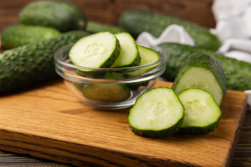 Sliced cucumber.Fresh cucumbers on brown texture background. Sliced cucumber slices for salad.Vegetarian organic vegetables.Healthy food.Copy space.Place for text