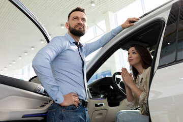 A young wife persuades a man to buy her a new car at a car dealership