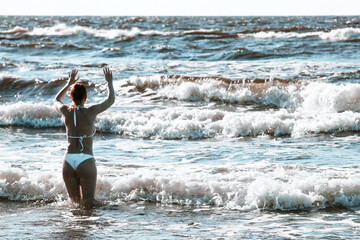 woman in bikini,a girl in a white swimsuit, with a charming figure, swimming in the sea, a beautiful girl