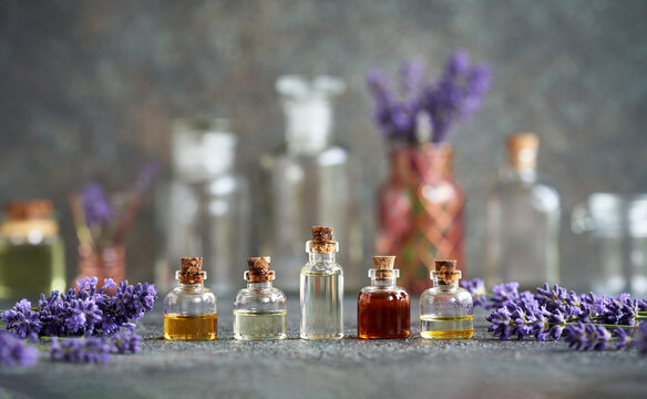 Several bottles of essential oil with fresh lavender flowers