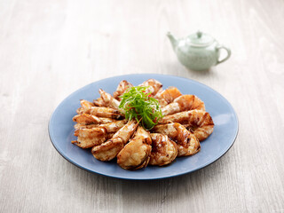 Wok-fried Sea Prawns in Supreme Soya Sauce with chopsticks served in a dish isolated on mat side view on grey background