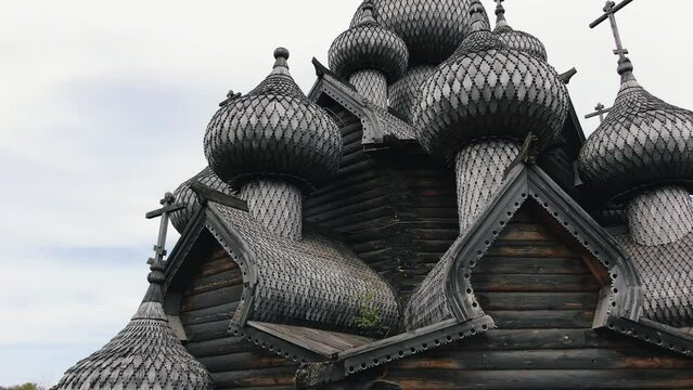 Old Orthodox temple made of wooden planks and large domes with crosses against cloudy sky. Ancient sanctuary as popular tourist destination aerial view
