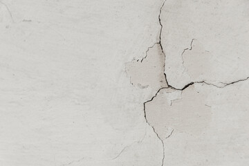 Old wall with white plaster and cracked peeling texture. Grunge cracked concrete wall with copy space