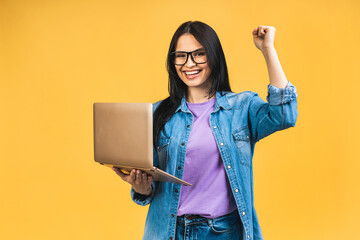 Happy winner! Portrait of attractive surprised excited smiling business woman with laptop, isolated over yellow background, Winner with success. - 511121122